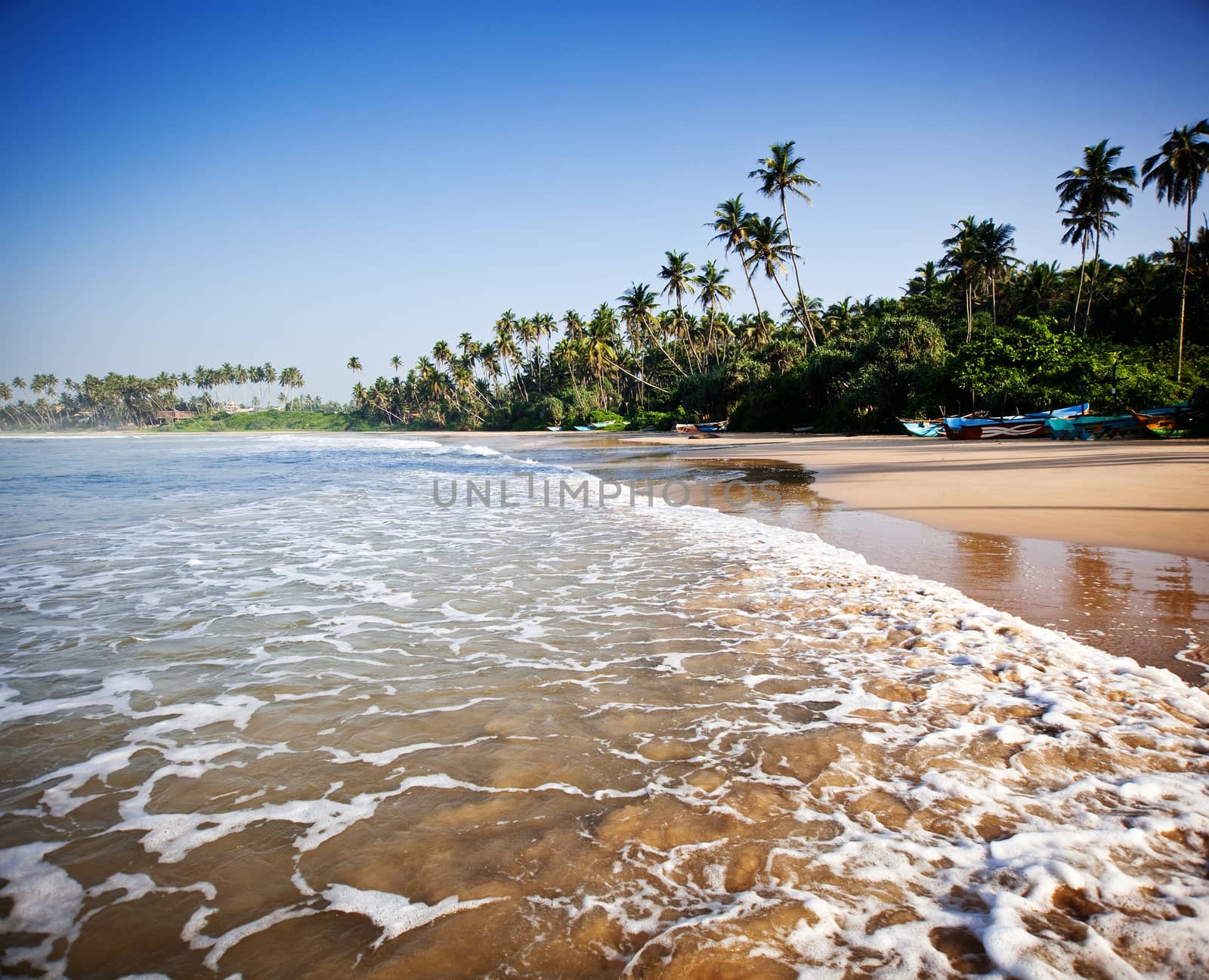 Untouched tropical beach with fishing boat in Sri Lanka