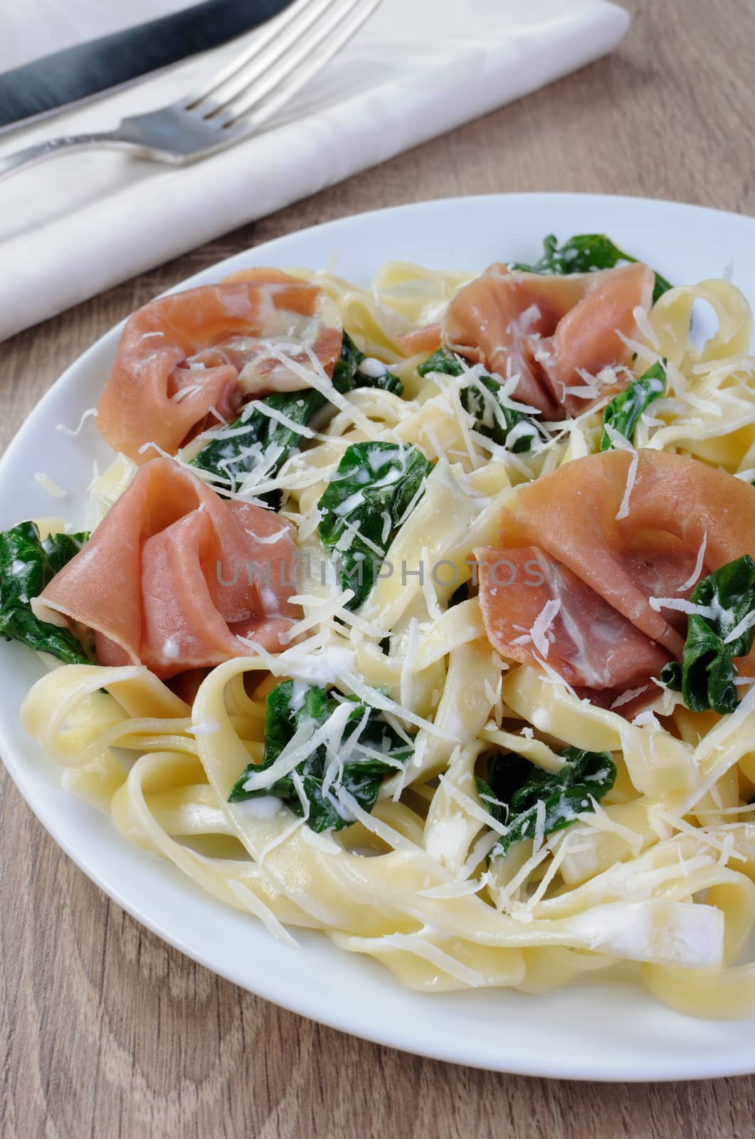 Pasta with spinach, ham and parmesan cheese for milk sauce