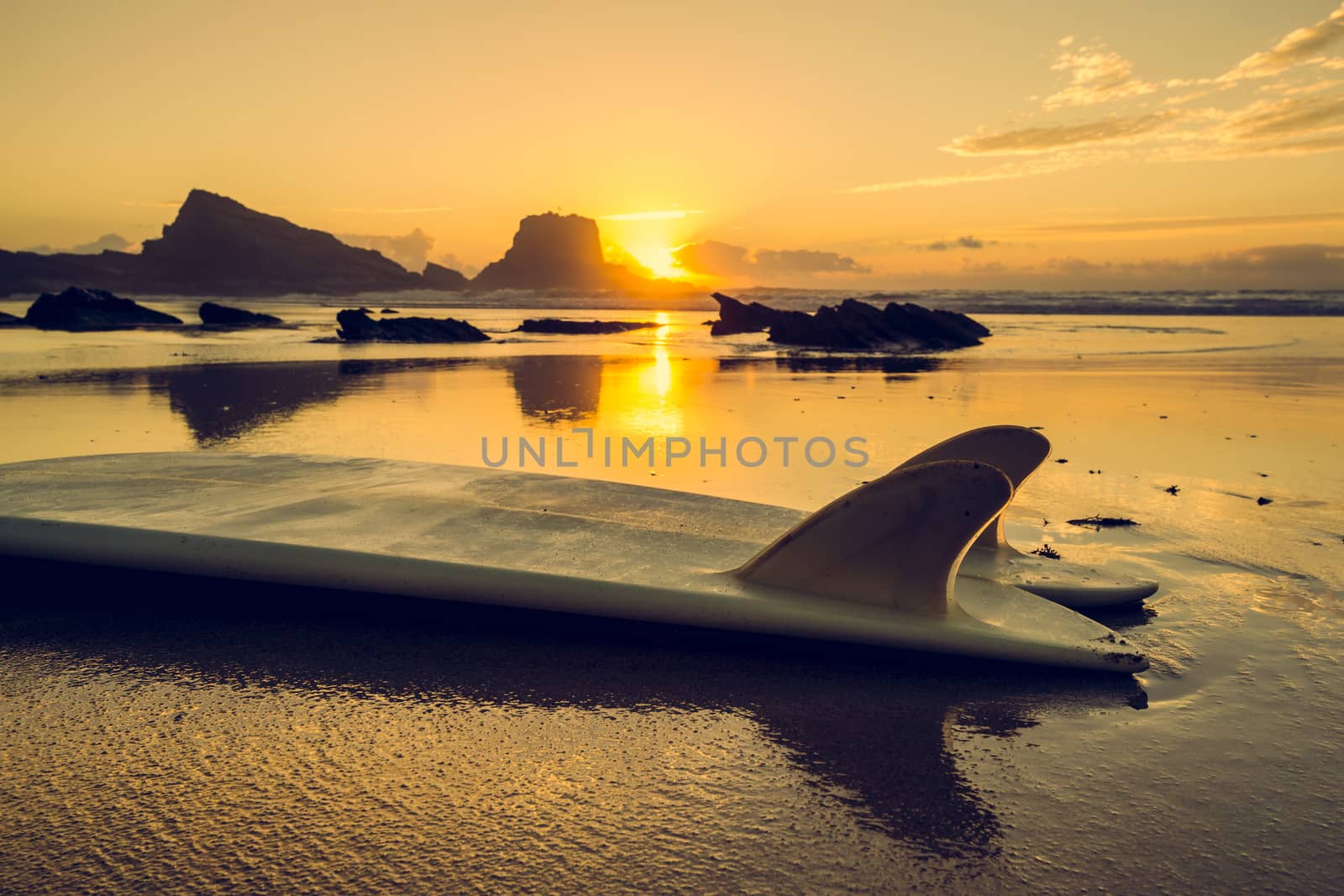 Silhouette of a surfboard at the beach with reflection 