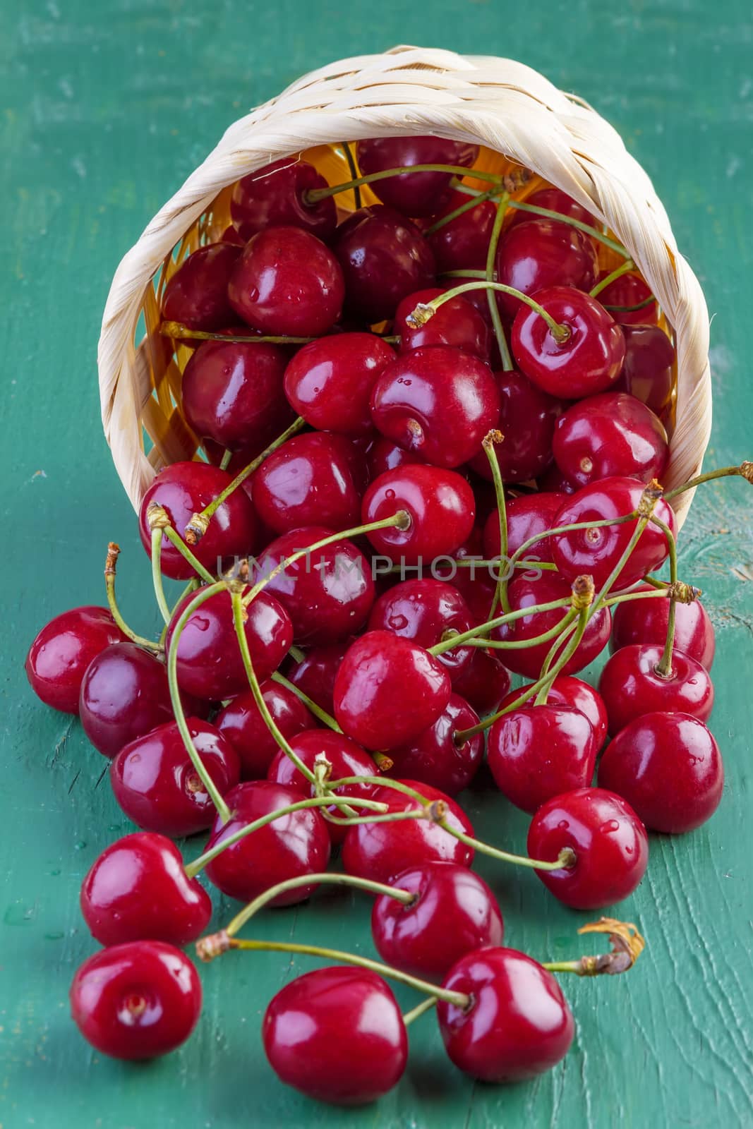 fresh cherries on green wooden table