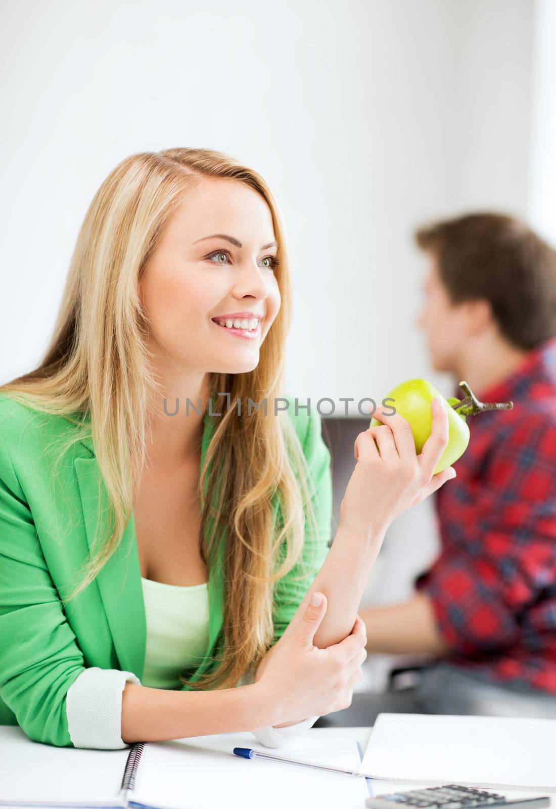 student girl with green apple in college by dolgachov