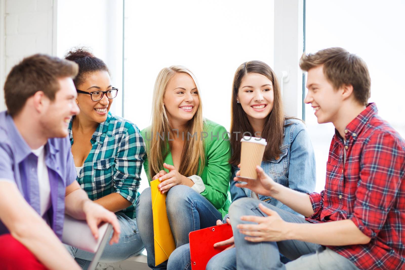 students communicating and laughing at school by dolgachov