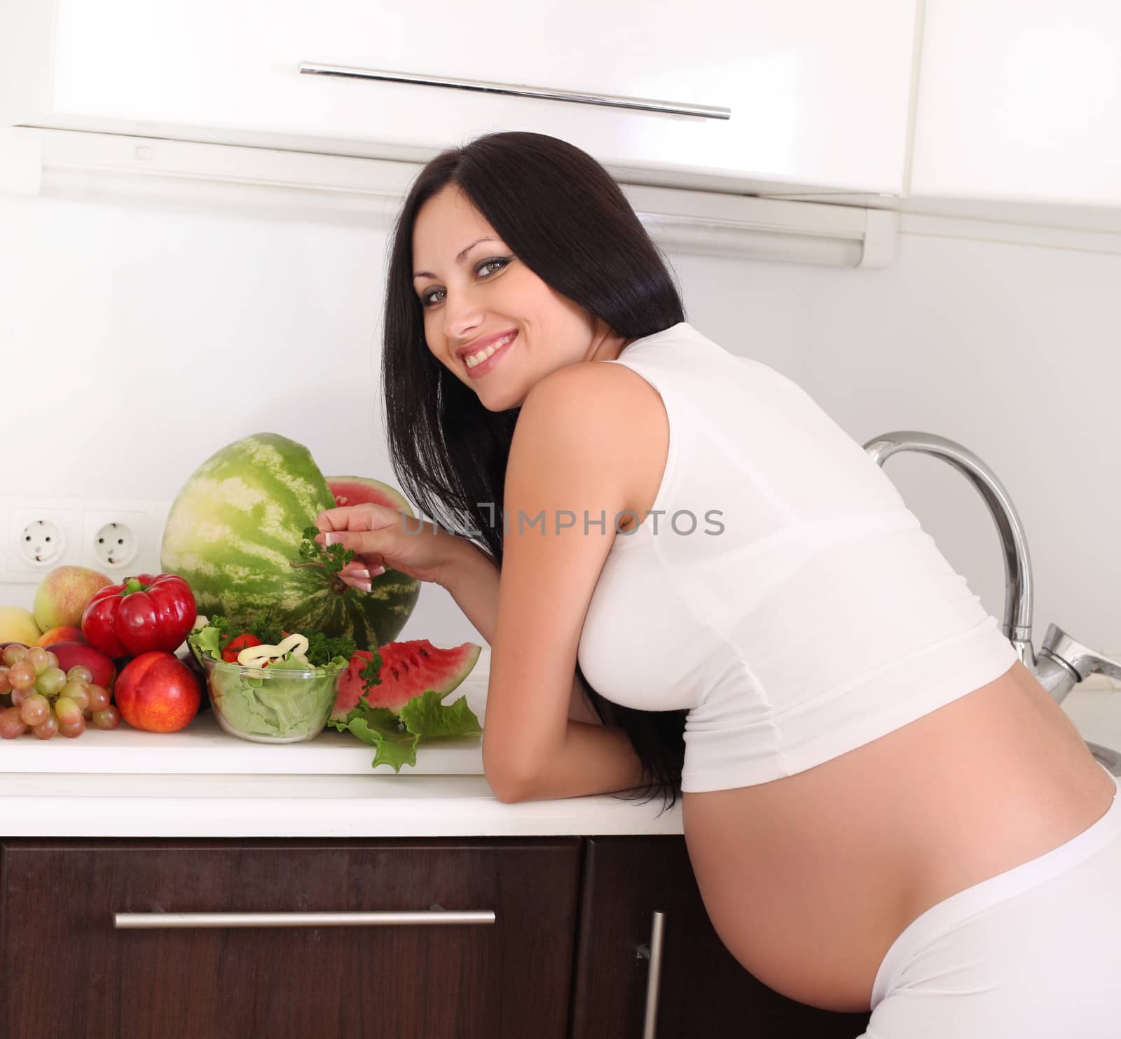 pregnant woman in kitchen by rudchenko