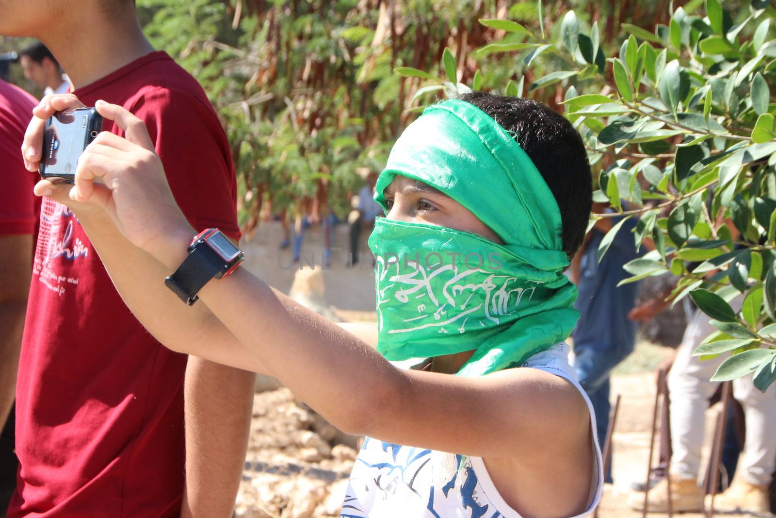 PALESTINE, Hebron: Violence continued in Hebron, Palestine on October 21, 2015 as Palestinians' held a funeral service for a fallen man. A young Palestinian take a picture during the funeral service.Hebron was the latest scene of violence as an IDF soldier was stabbed by an attacker on Tuesday. The attacker was shot and killed after the stabbing. 