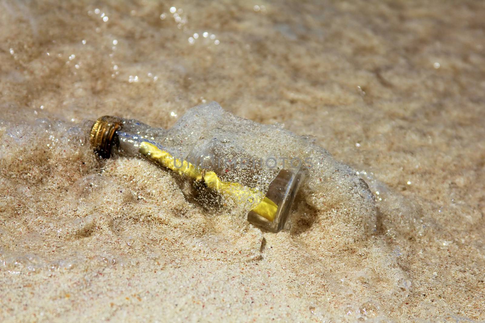 Message in the bottle on sand background