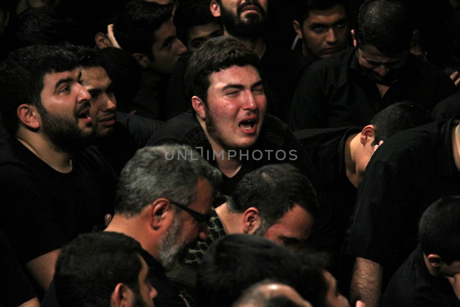 IRAN, Tehran : A man cries during a religion celebration while hundreds of Shia Muslims gather in Reyhane-Al-Hossein complex building for mourning session in tribute to imam Husayn ibn Ali on October 21, 2015, the 8th night of Muharram. one of the holy months in the Islamic calendar in Tehran, Iran. 