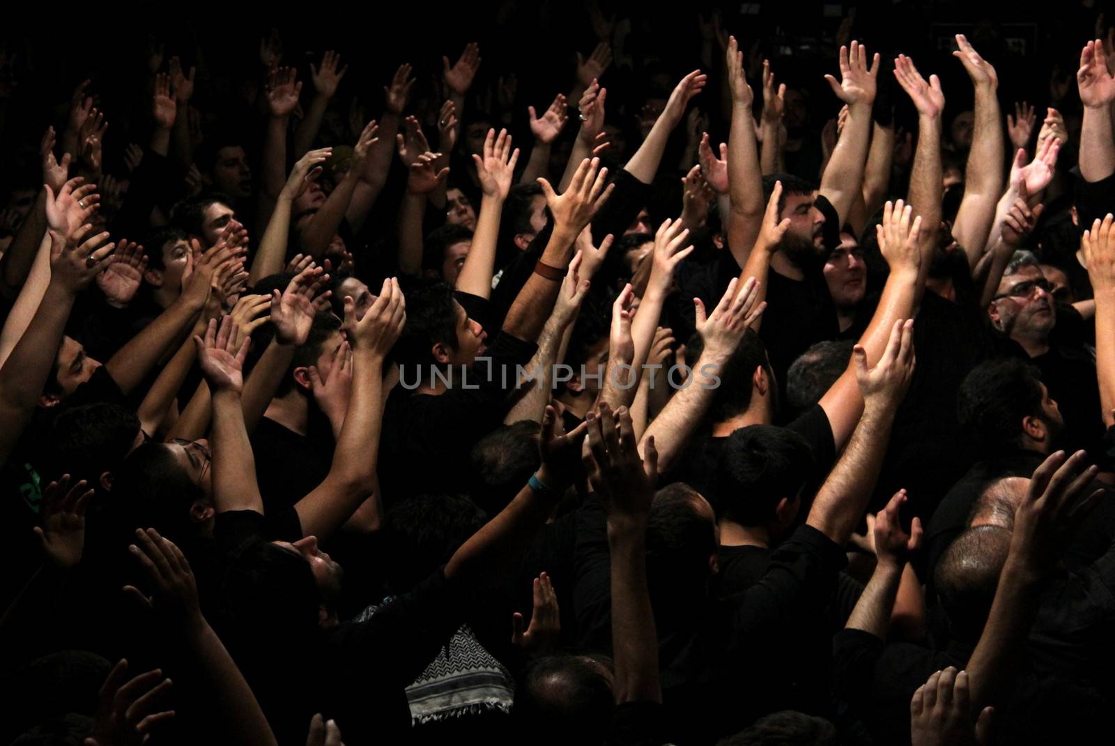 IRAN, Tehran : Hundreds of Shia Muslims raise their arms in Reyhane-Al-Hossein complex building for mourning session in tribute to imam Husayn ibn Ali on October 21, 2015, the 8th night of Muharram. one of the holy months in the Islamic calendar in Tehran, Iran. 