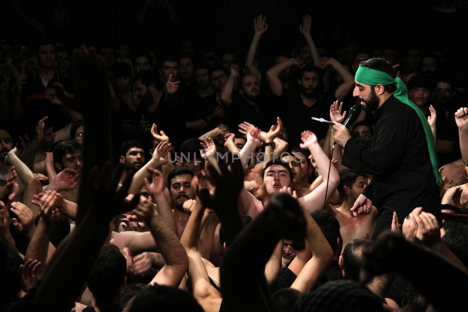 IRAN, Tehran : Hundreds of shirtless Shia Muslims raise their arms in Reyhane-Al-Hossein complex building for mourning session in tribute to imam Husayn ibn Ali on October 21, 2015, the 8th night of Muharram. one of the holy months in the Islamic calendar in Tehran, Iran. 