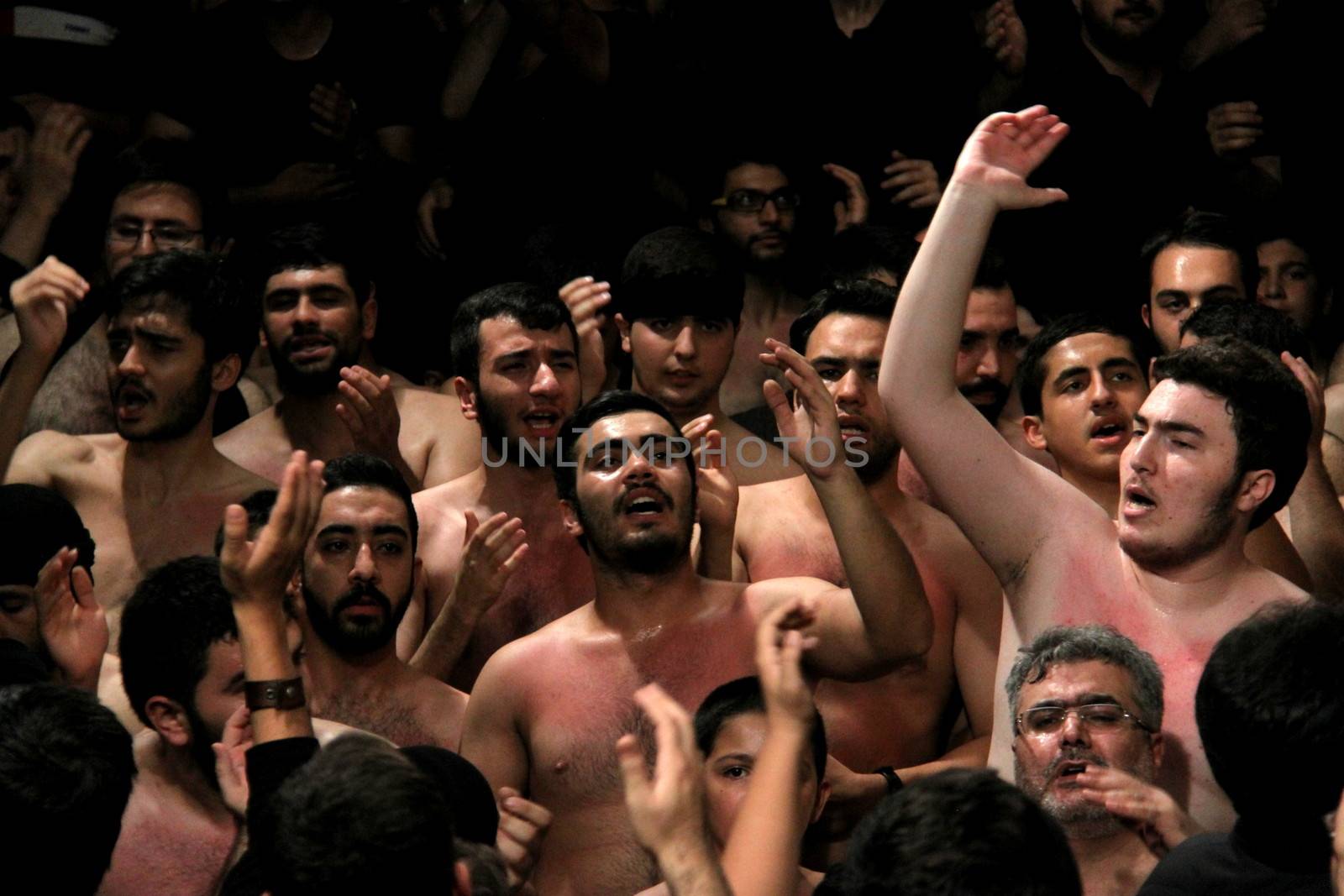 IRAN, Tehran : Hundreds of shirtless Shia Muslims shout in Reyhane-Al-Hossein complex building for mourning session in tribute to imam Husayn ibn Ali on October 21, 2015, the 8th night of Muharram. one of the holy months in the Islamic calendar in Tehran, Iran. 