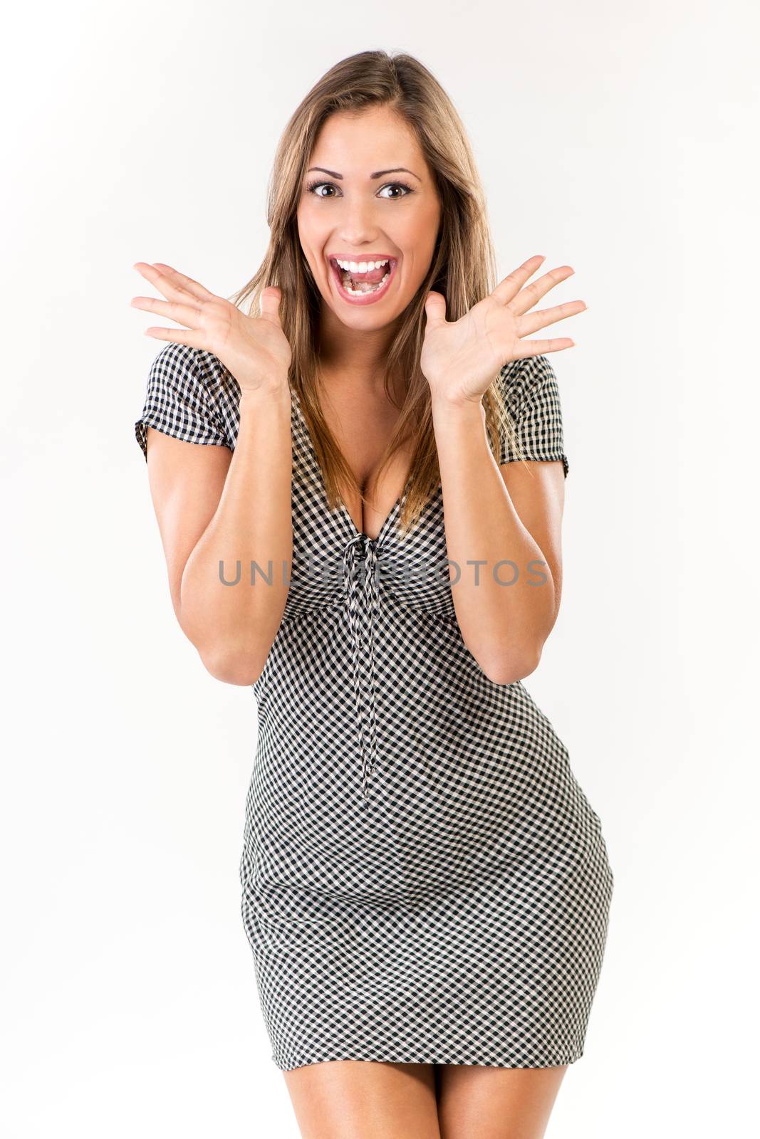 Excited surprised young woman in dress. Looking at camera. White background.