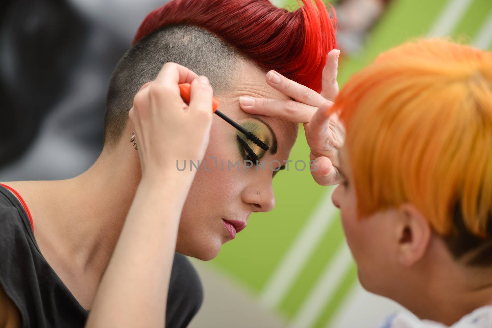 Make-up artist applying the mascara to model. Close up. 
