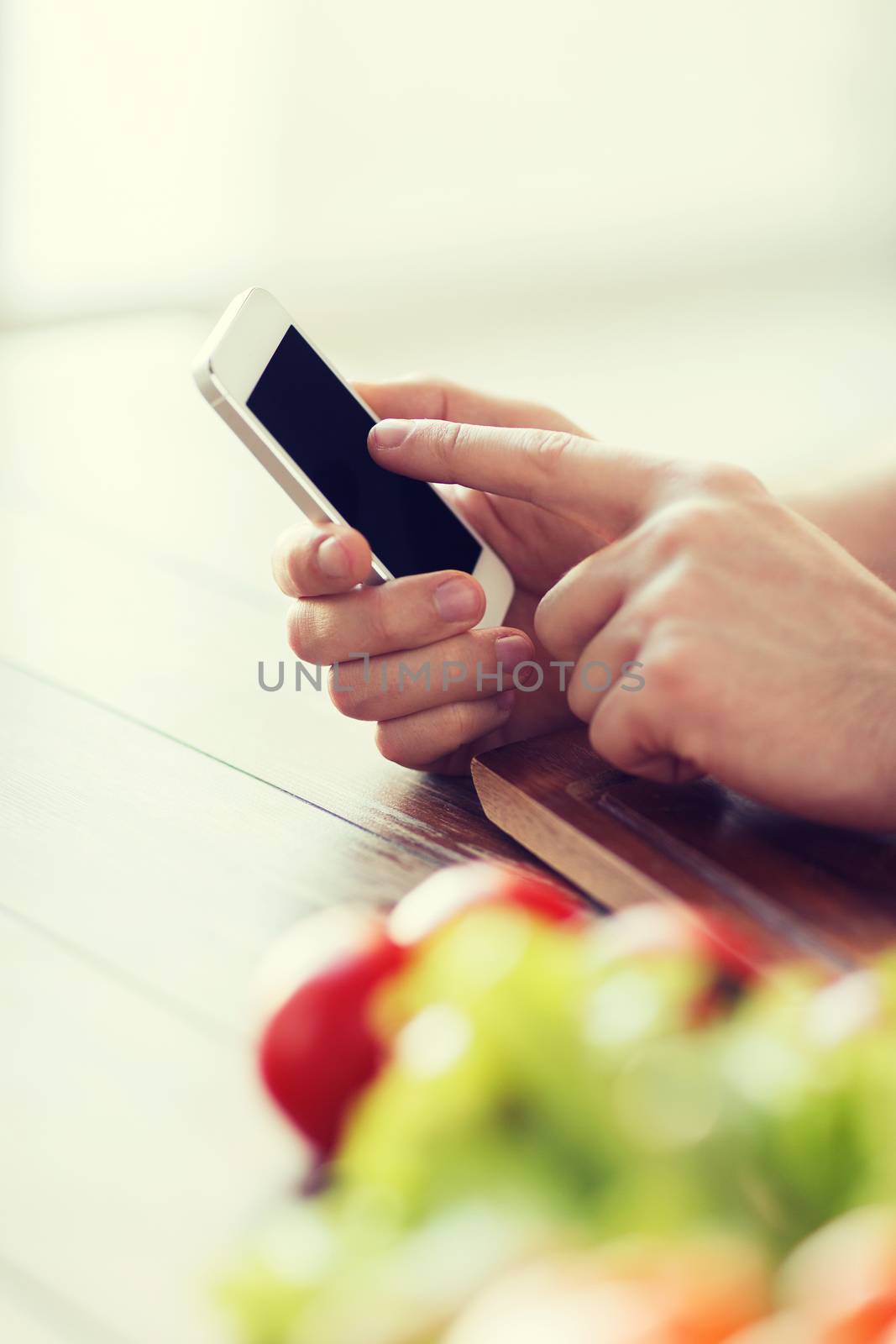 closeup of male hand pointing finger to smartphone by dolgachov