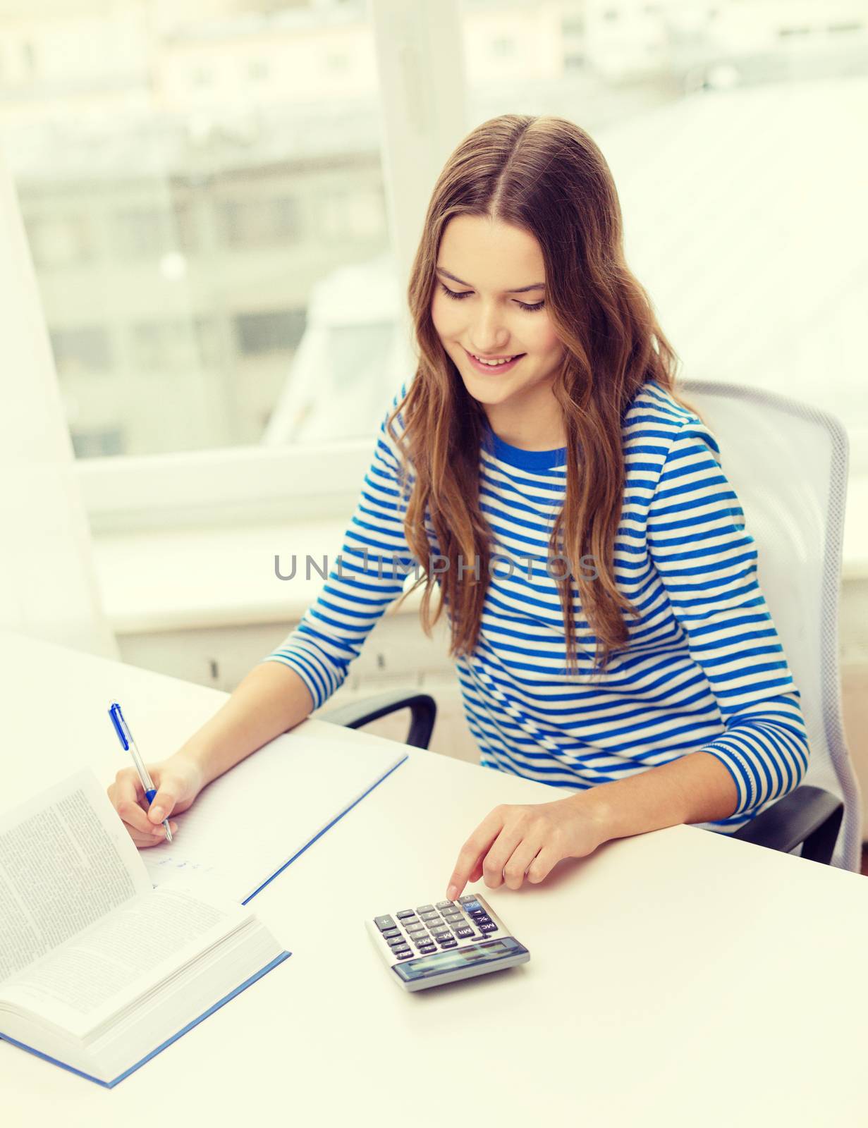 education and home concept - happy smiling student girl with notebook, calculator and book