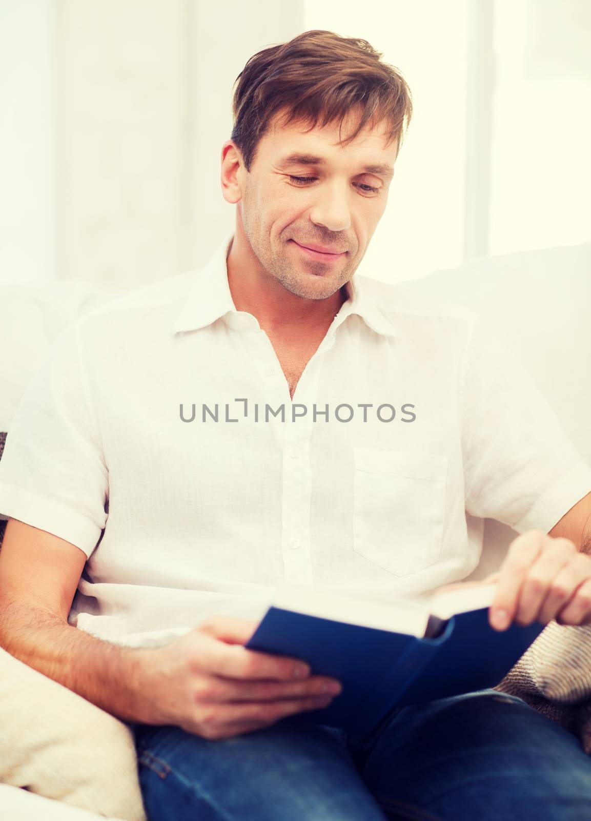 happy man with book at home by dolgachov