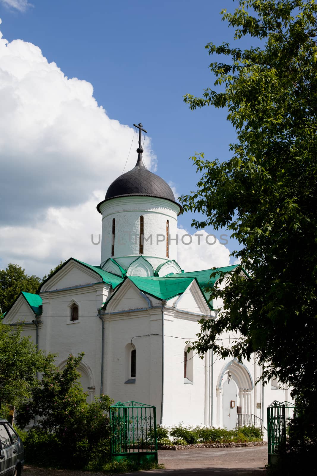 Small white orthodox church in a garden
