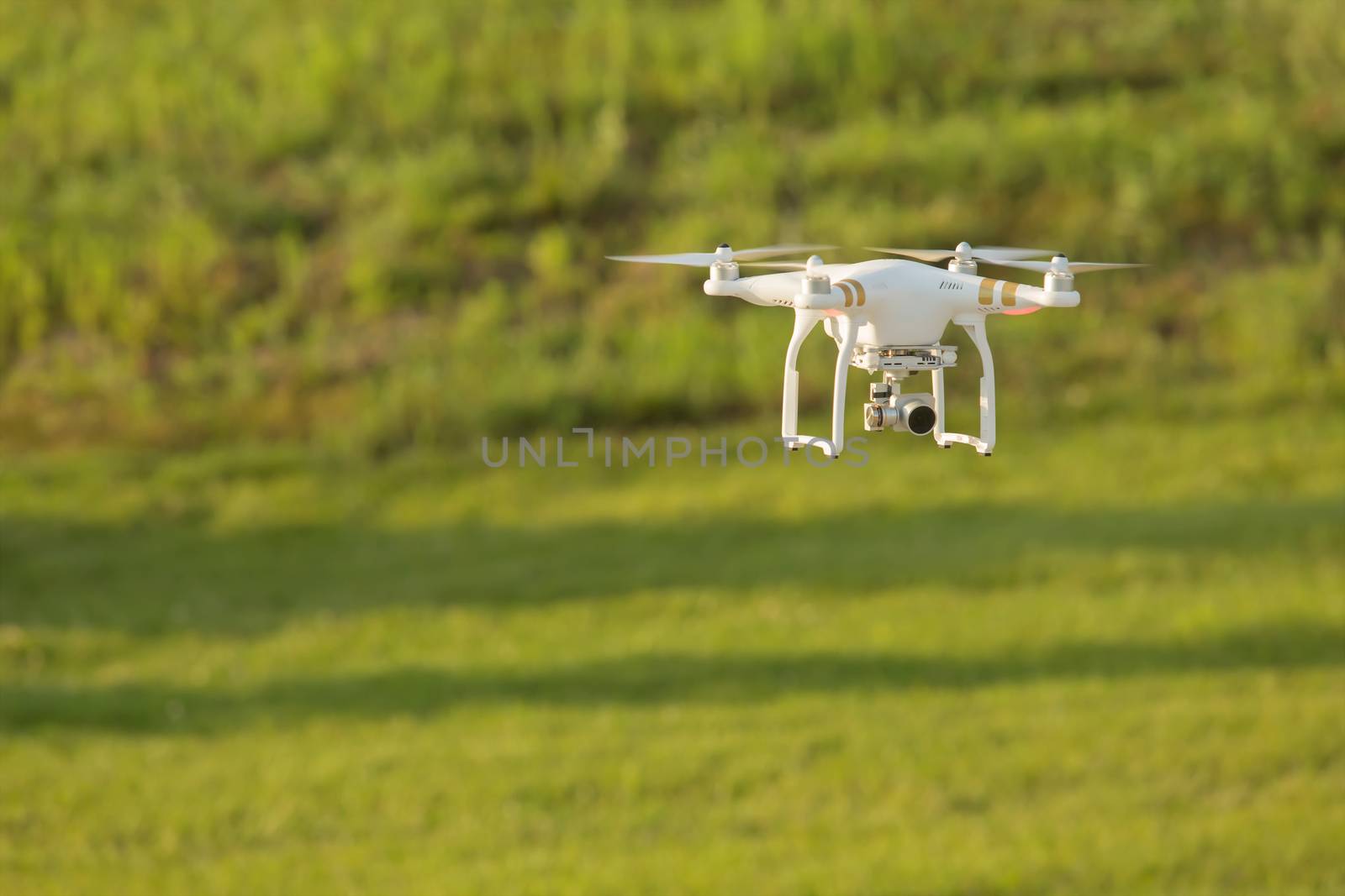 Remote control drone flying in mid air over a field