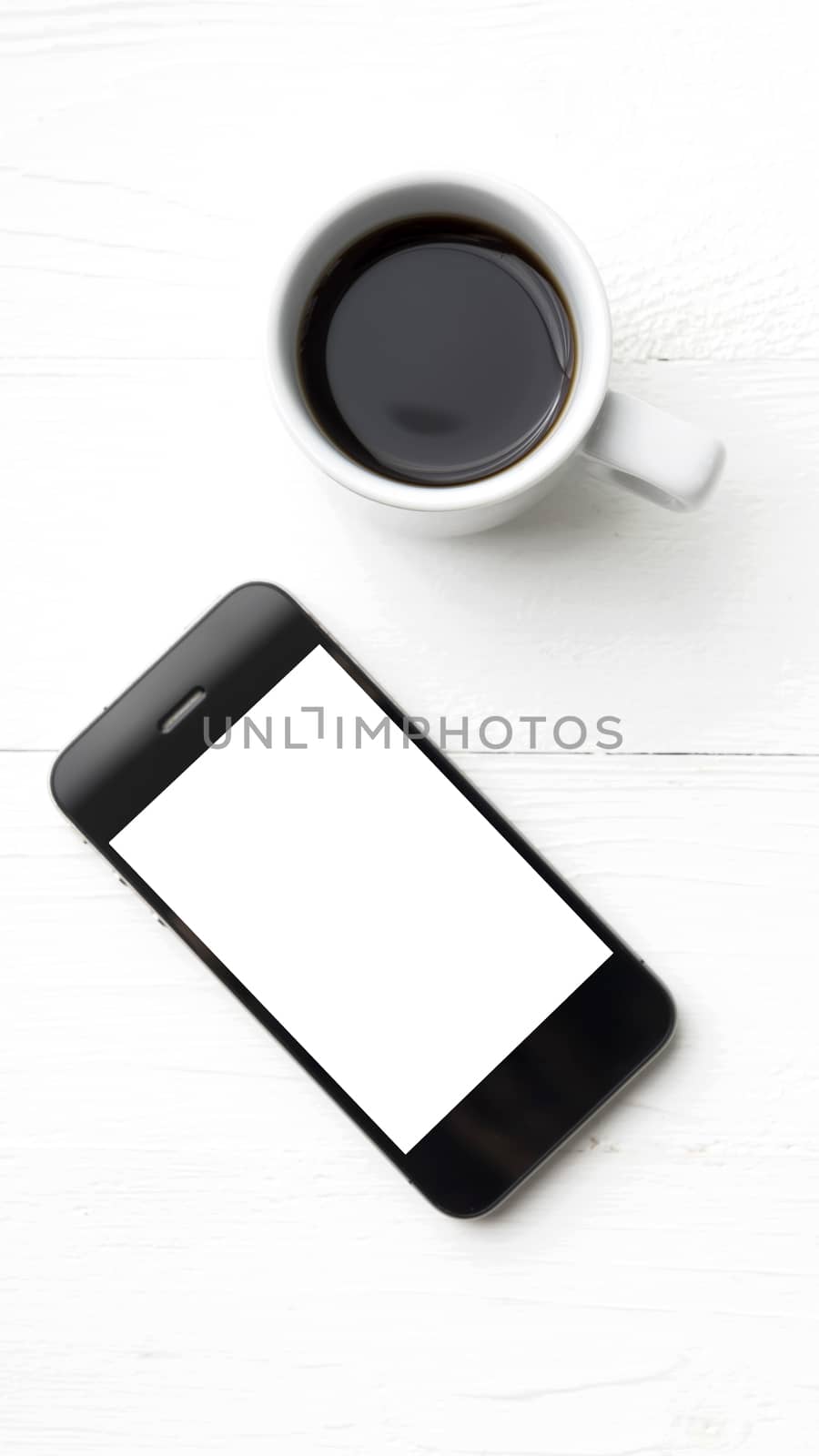 cellphone with coffee cup over white table