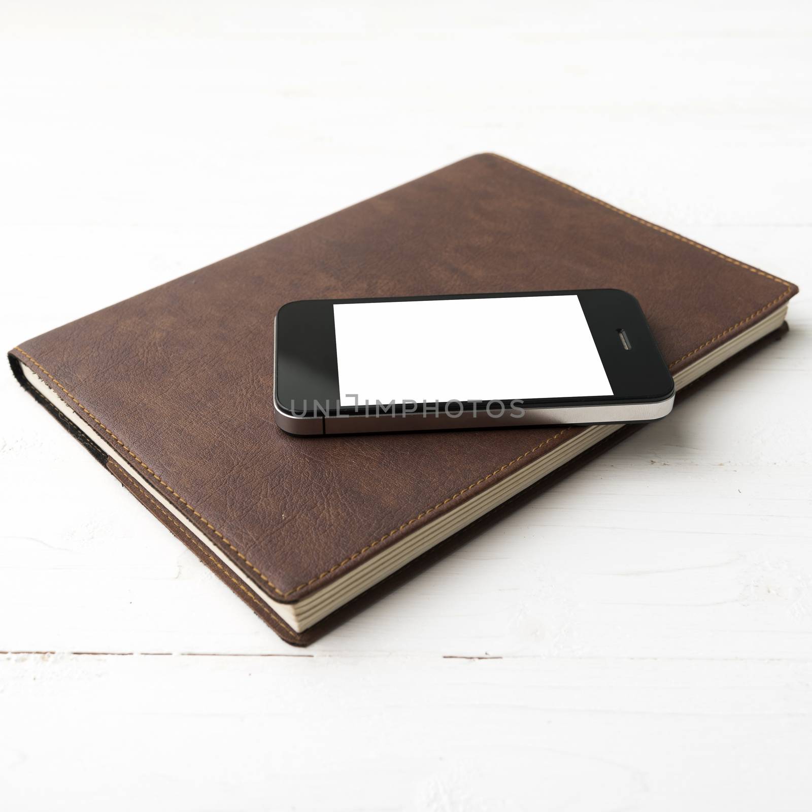 cellphone and notebook over white table