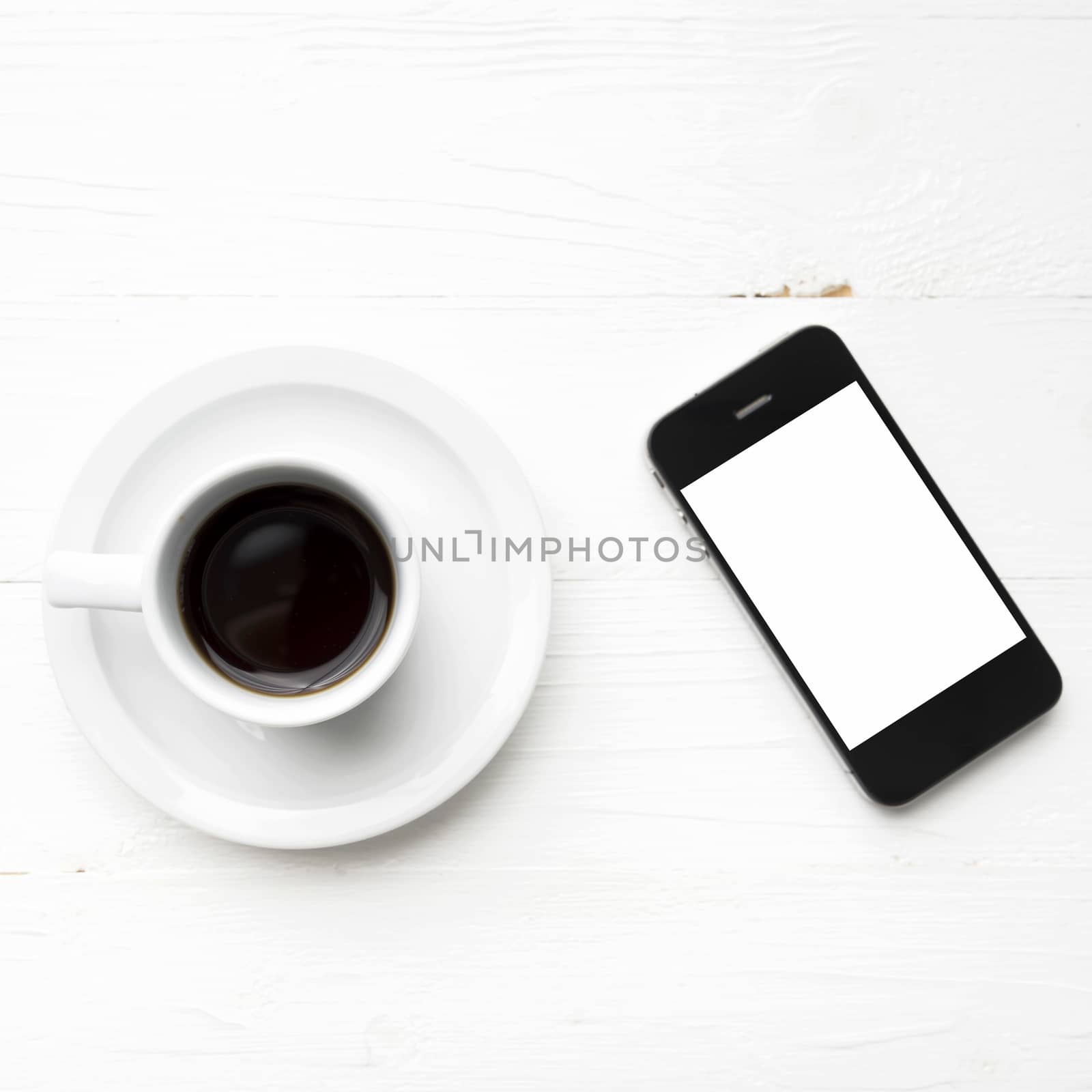 cellphone with coffee cup over white table
