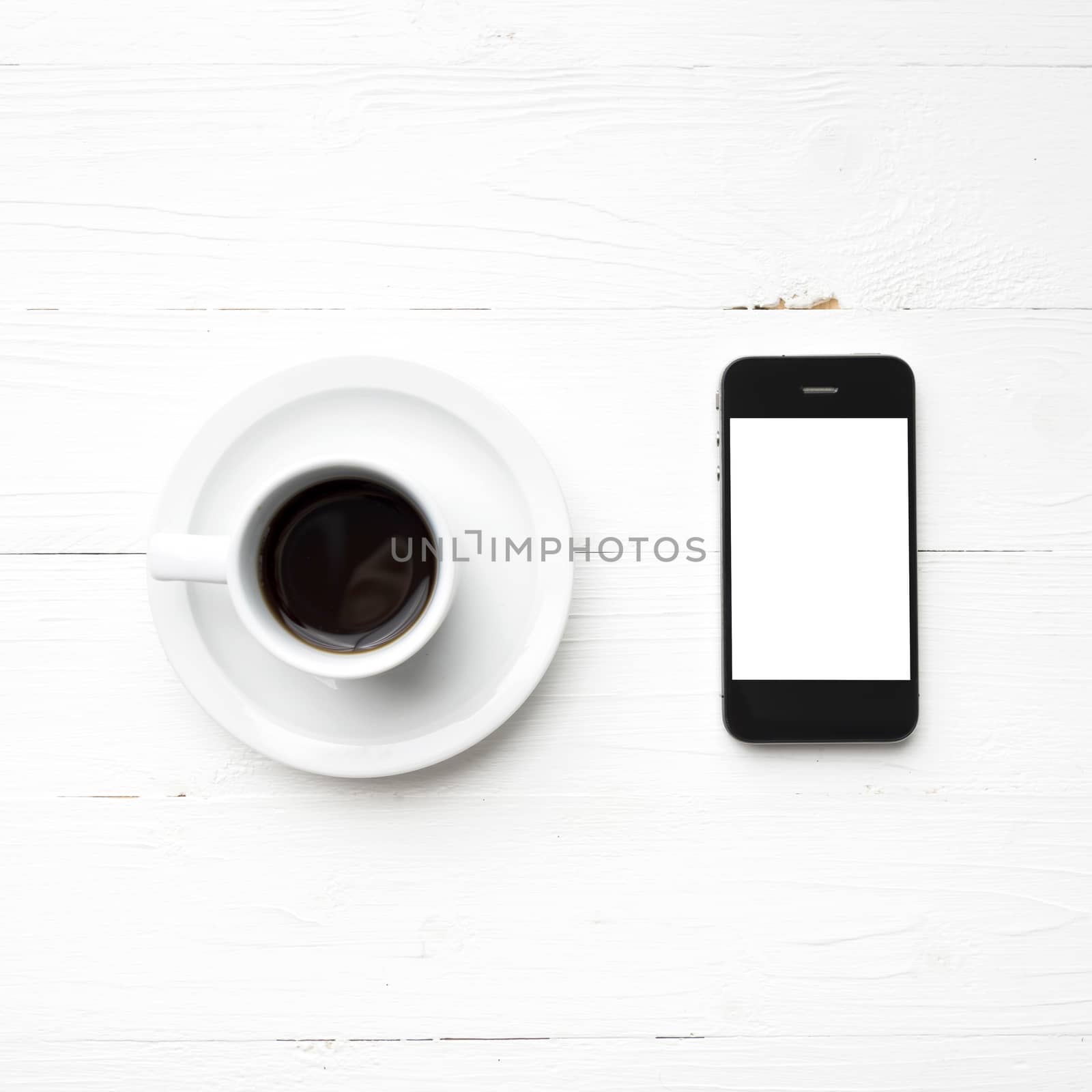 cellphone with coffee cup over white table