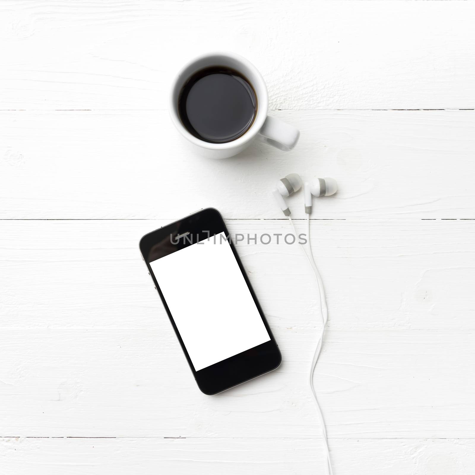 cellphone and coffee cup over white table