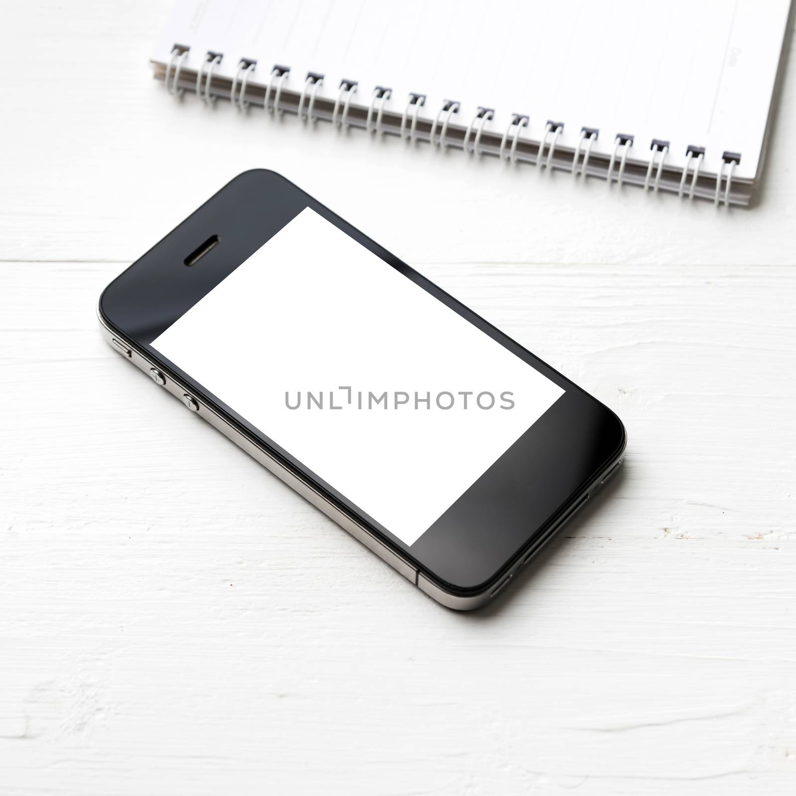 cellphone with notepad over white table