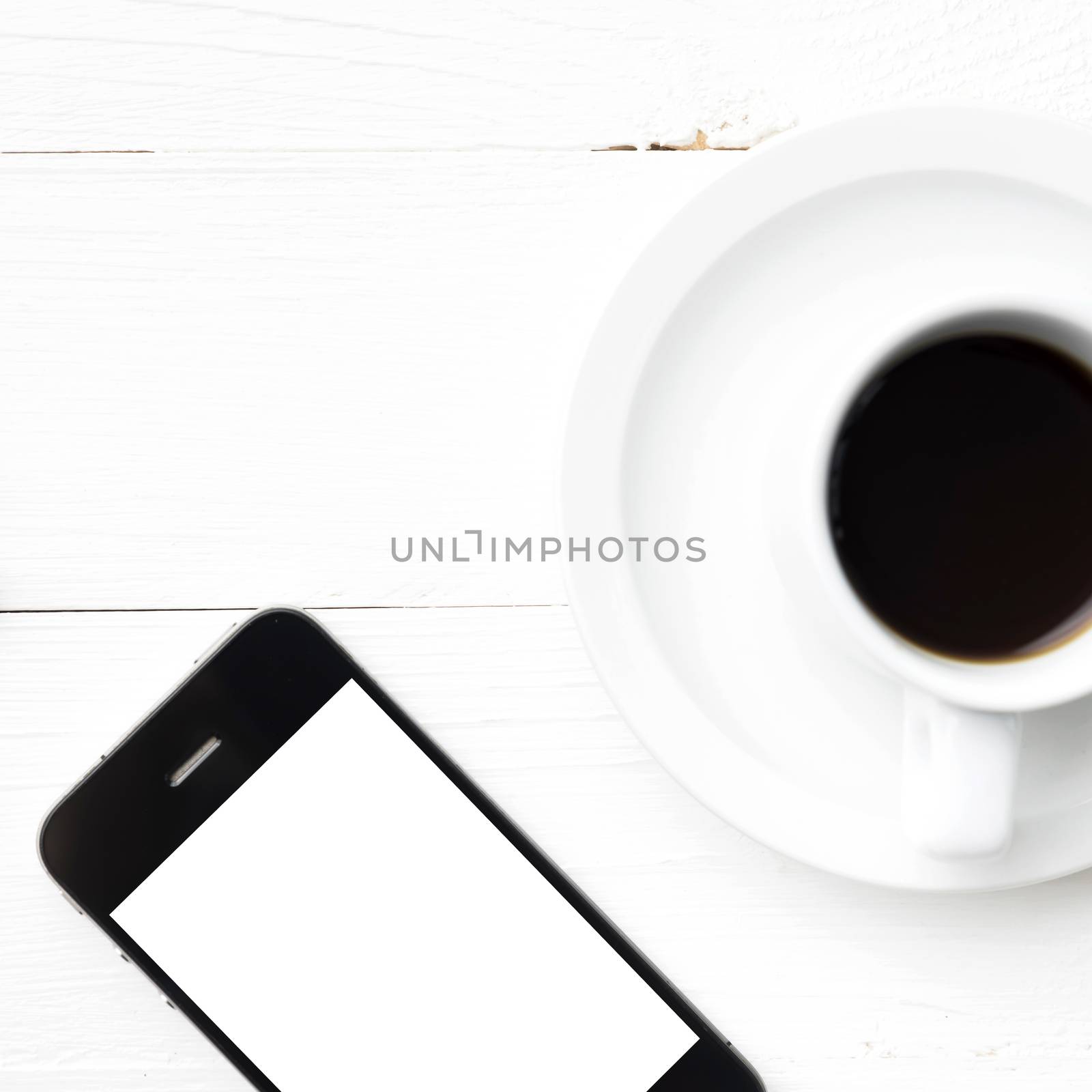 cellphone and coffee cup over white table