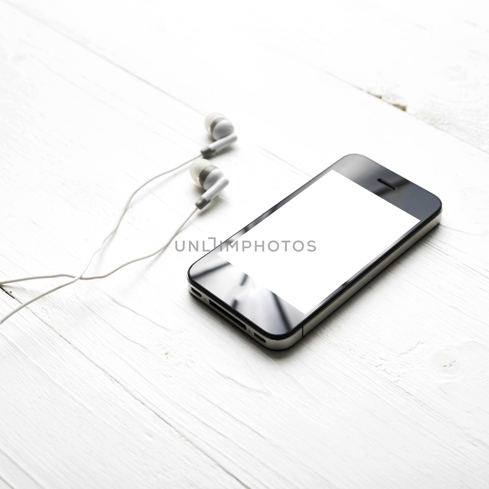 cellphone with earphone over white table