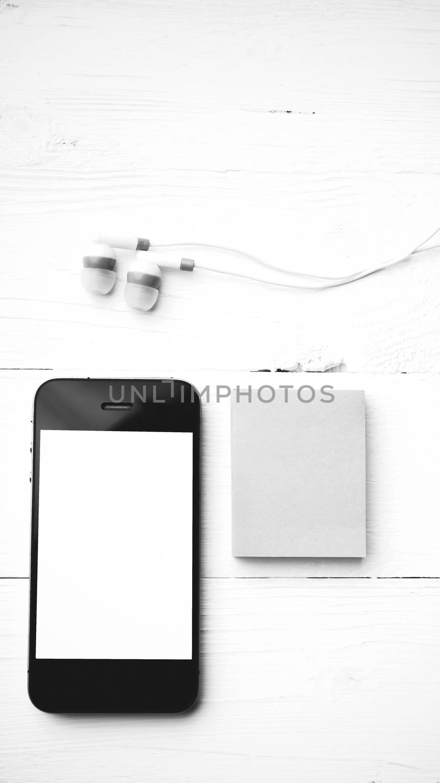 cellphone and sticky note over white table black and white color style