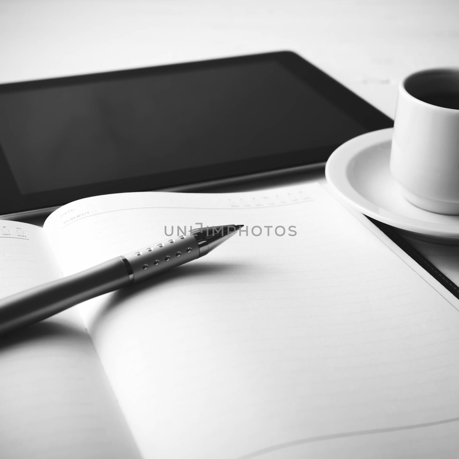 tablet with office supplies over white table black and white color style