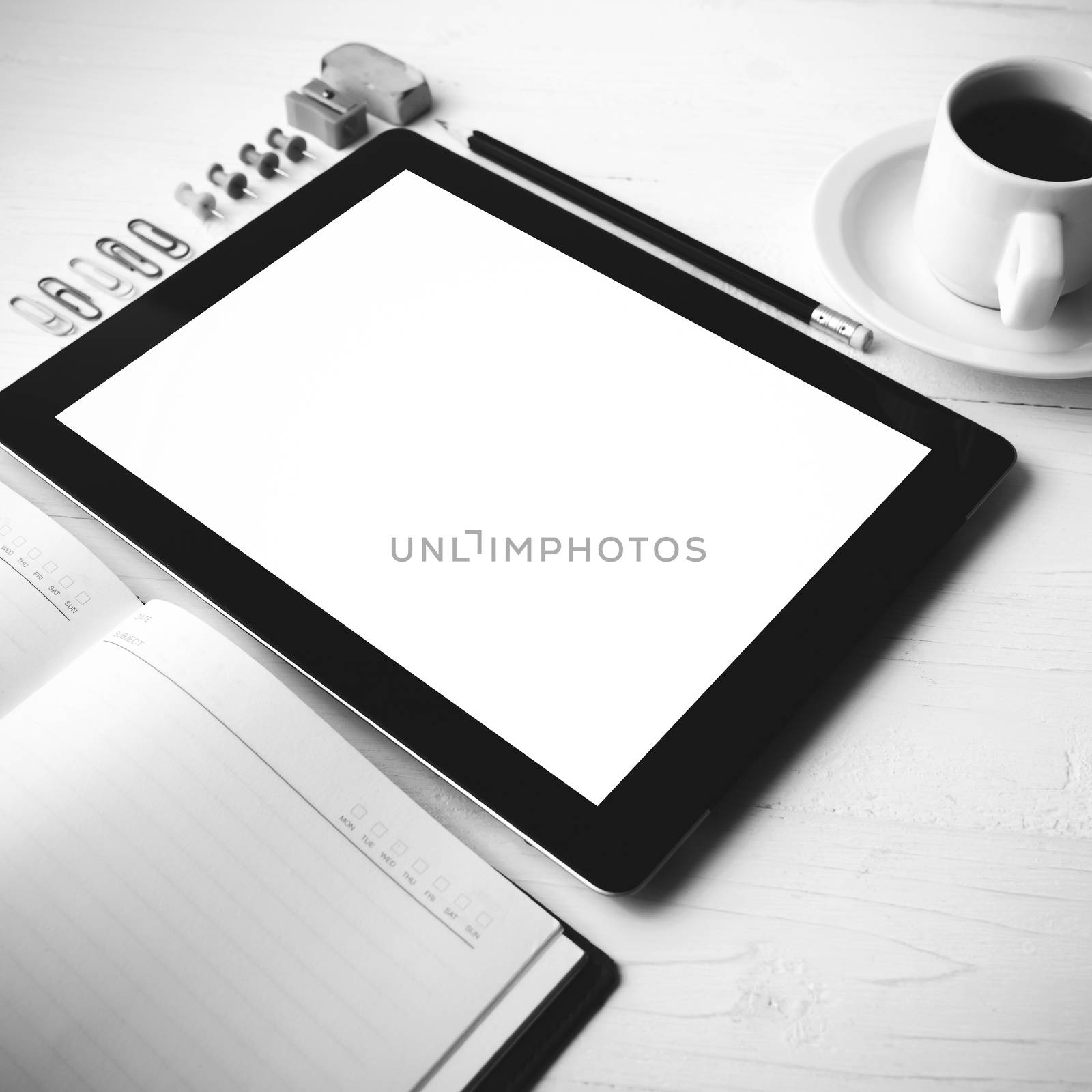 tablet with office supplies over white table black and white color style