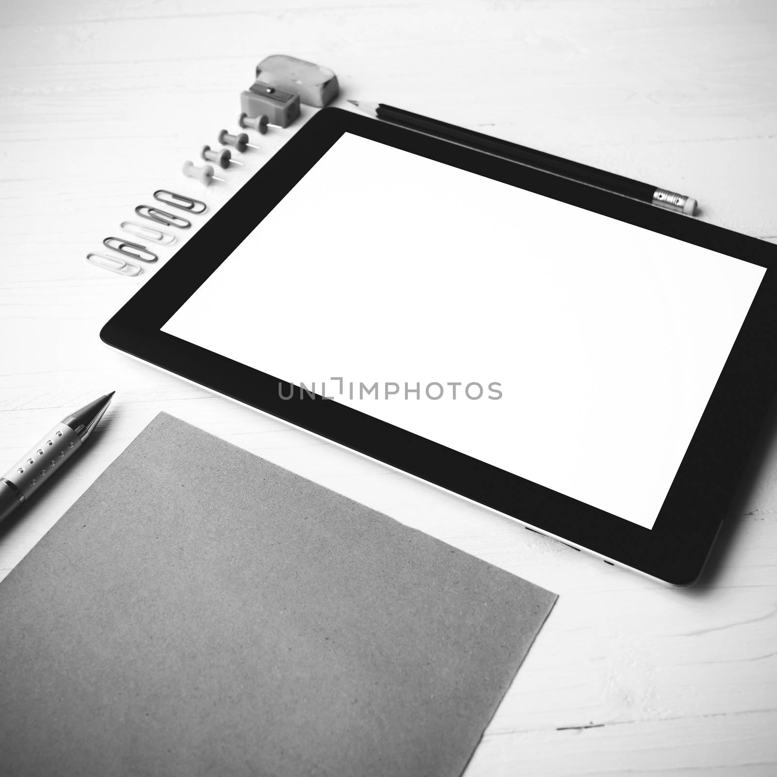 tablet with office supplies over white table black and white color style