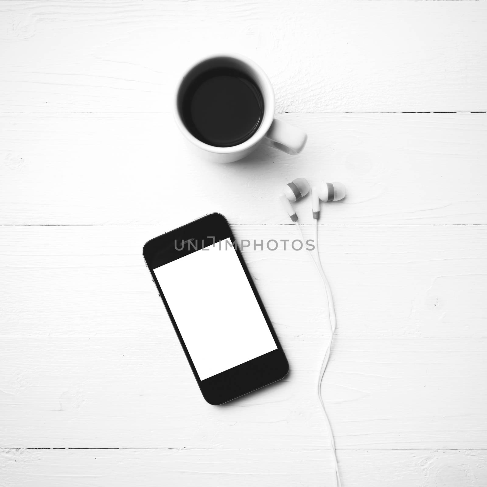 cellphone and coffee cup over white table black and white color style