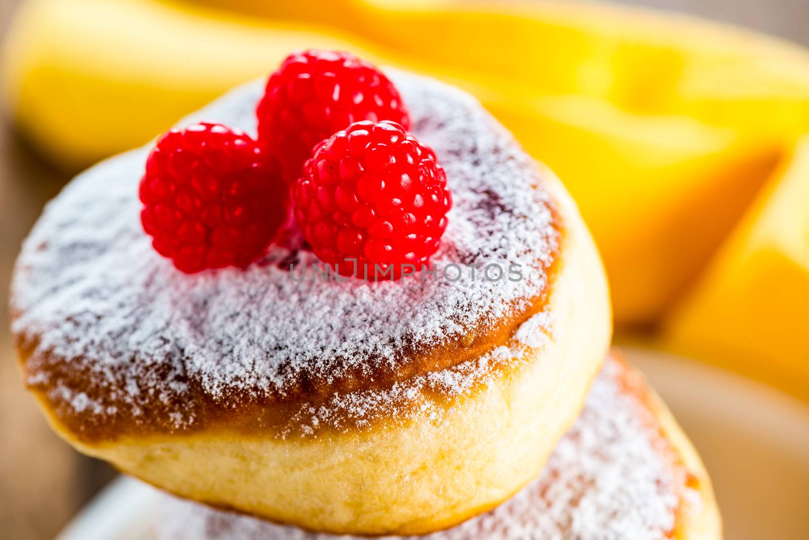 delicious german doughnuts powdered with sugar and raspberry on the top