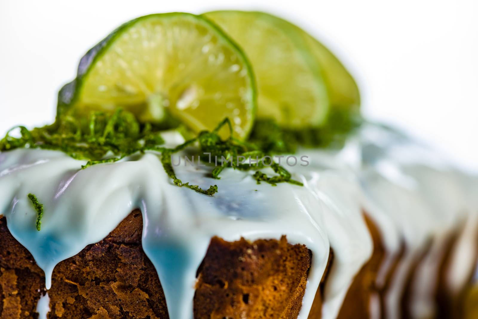 lemon loaf cake with icing decorating with lemon on white plate and blue wood table