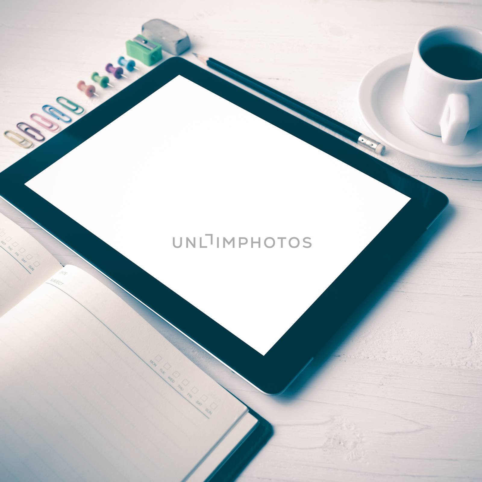 tablet with office supplies over white table vintage style