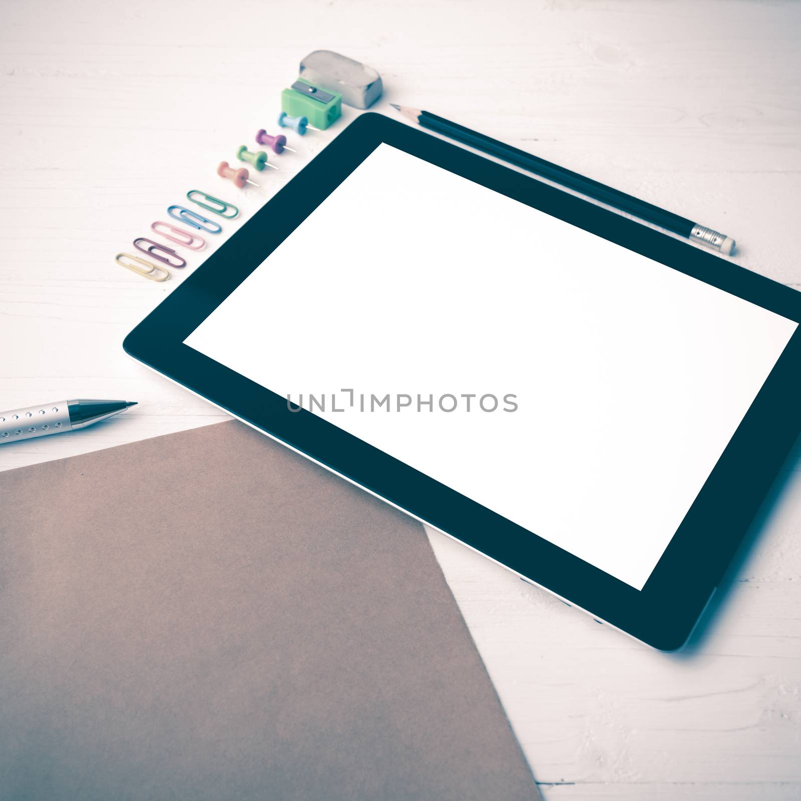 tablet with office supplies over white table vintage style