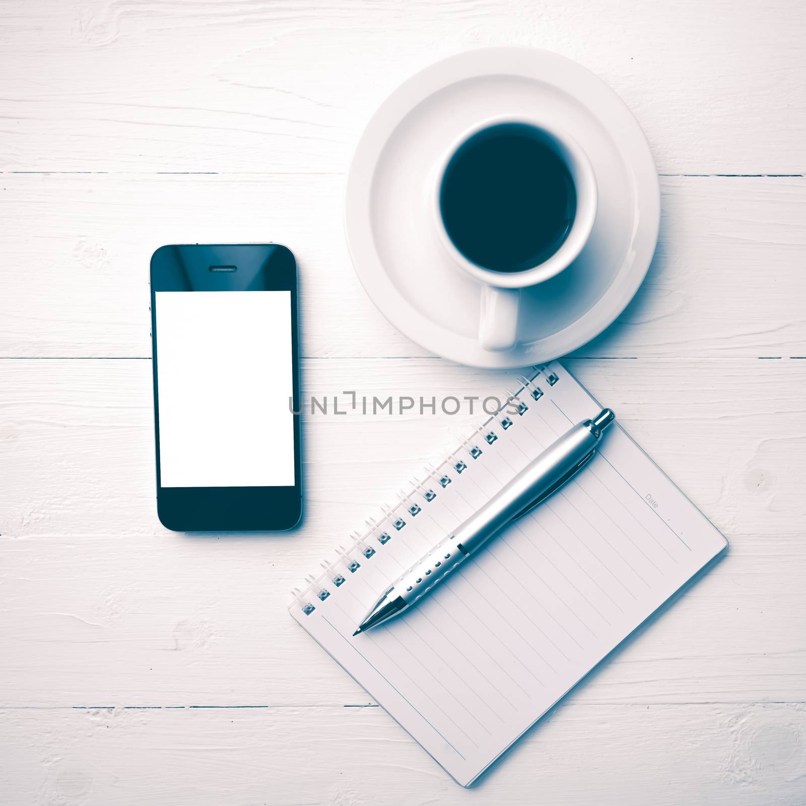 cellphone with notebook and coffee cup over white table vintage style