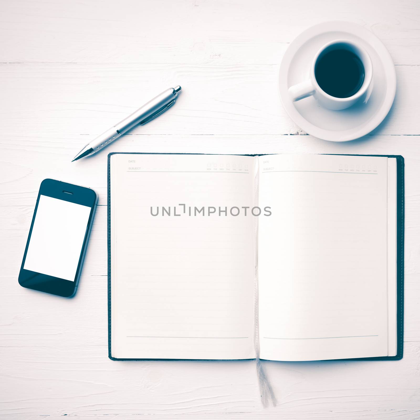 cellphone with notebook and coffee cup over white table vintage style