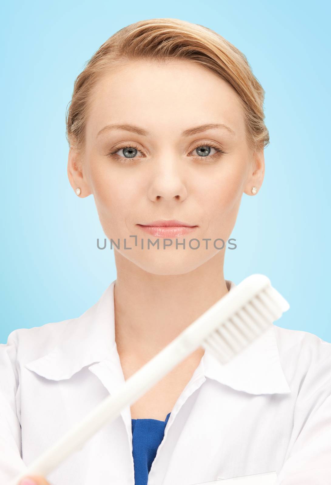 happy young female dentist with tooth brush by dolgachov