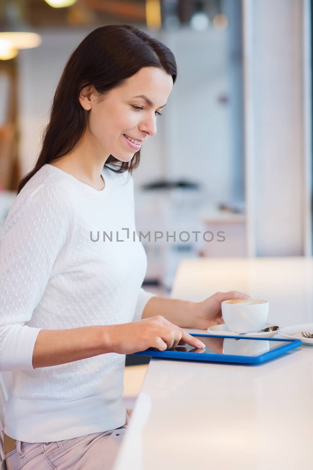 smiling woman with tablet pc and coffee at cafe by dolgachov