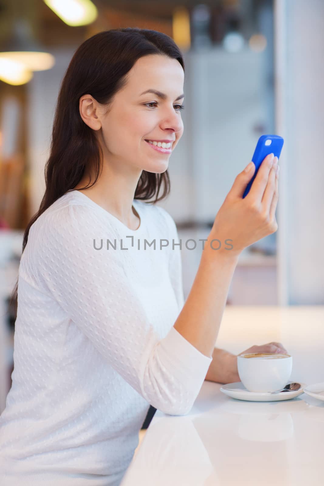 smiling woman with smartphone and coffee at cafe by dolgachov