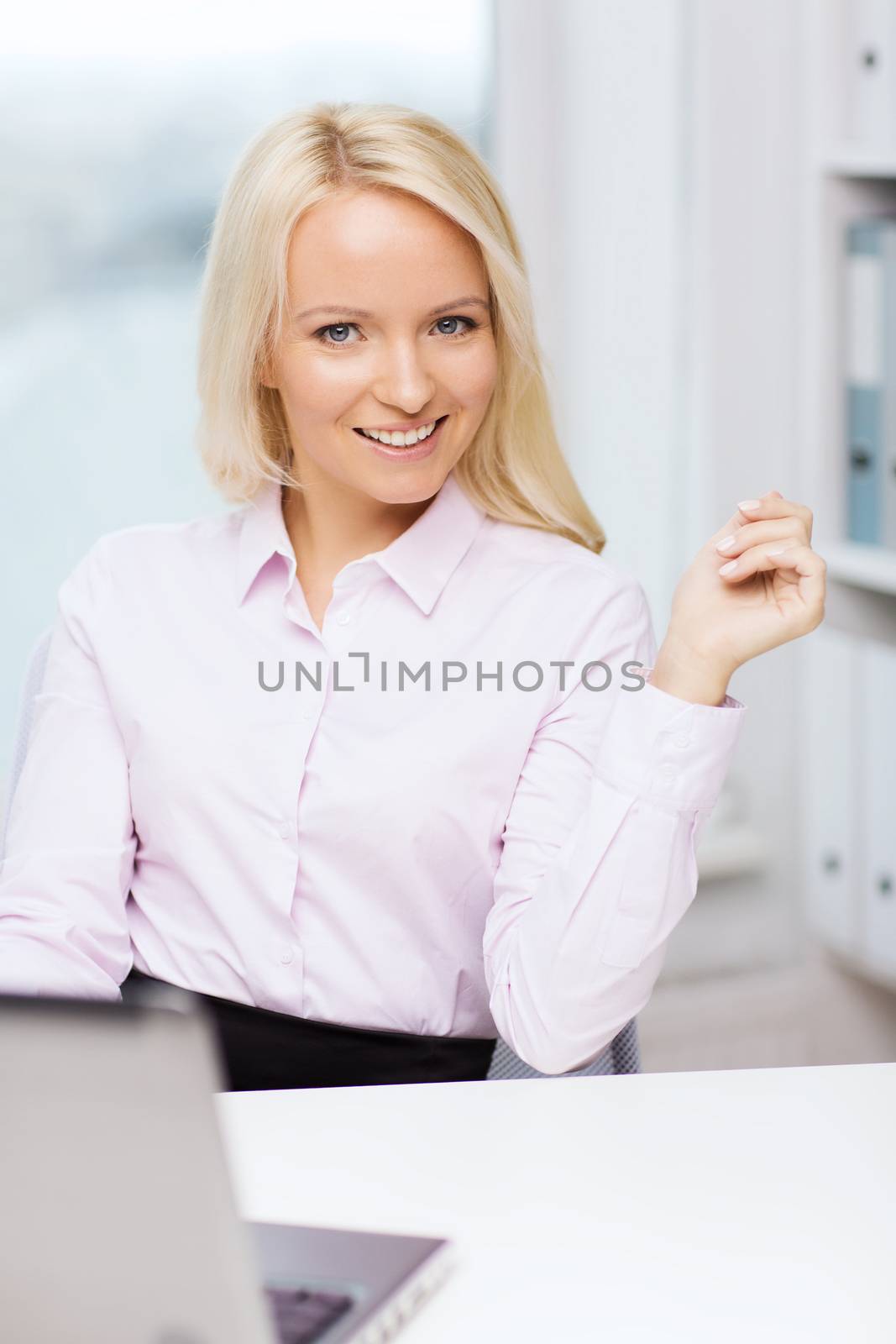 education, business and technology concept - smiling businesswoman or student with laptop computer in office