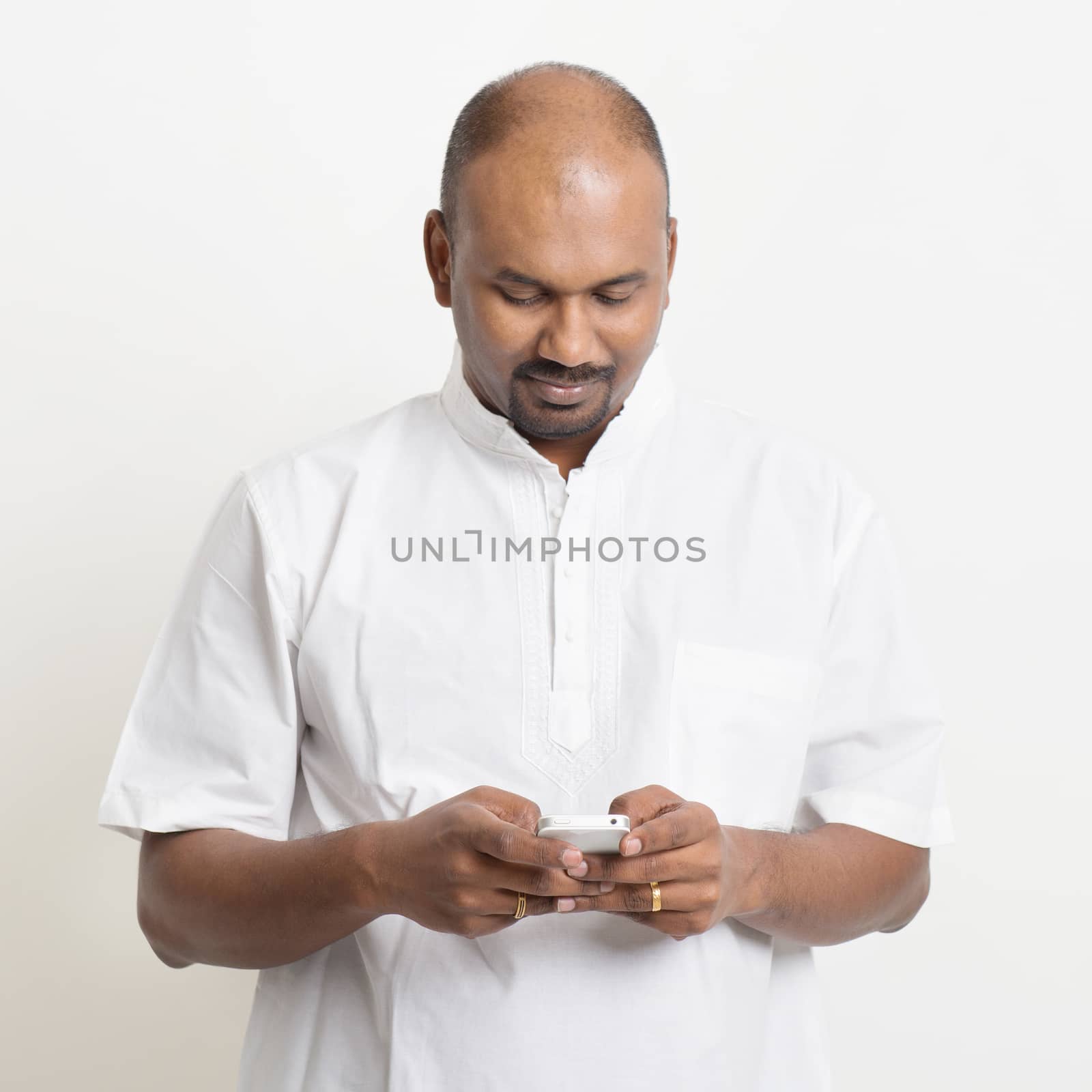 Mature casual business Indian man texting by szefei