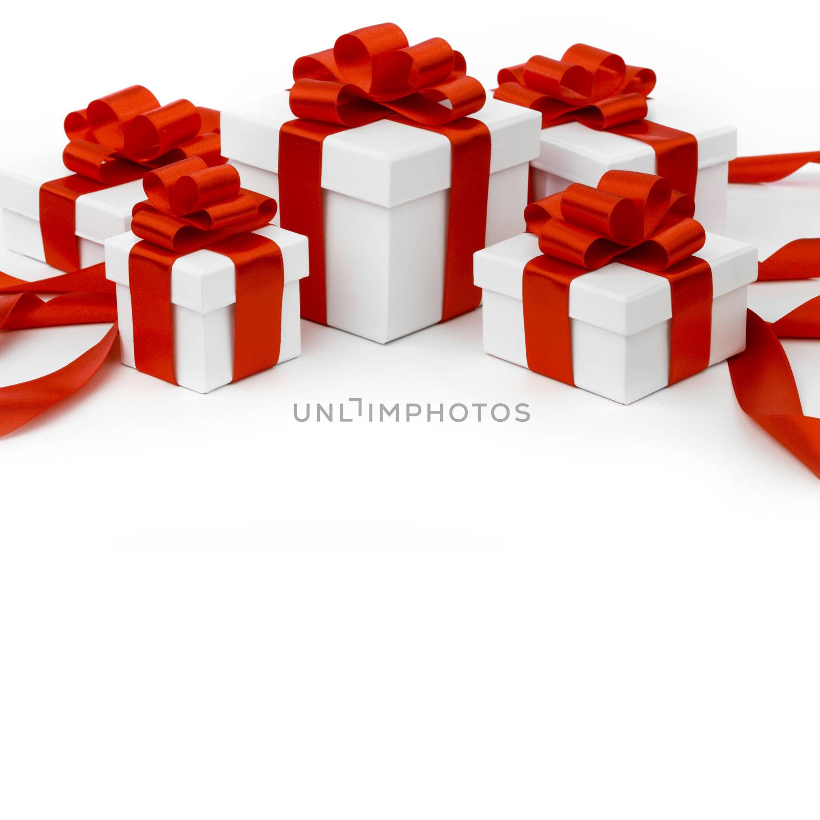 White gift boxes with red ribbon bows isolated on white background close-up