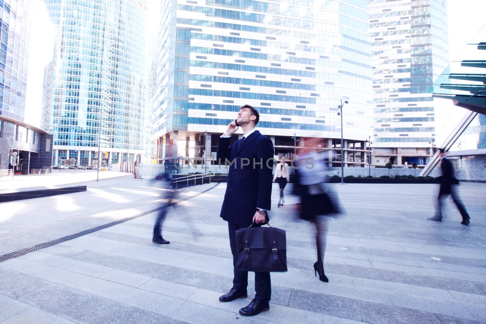 Handsome businessman talking on the cellphone outside office building