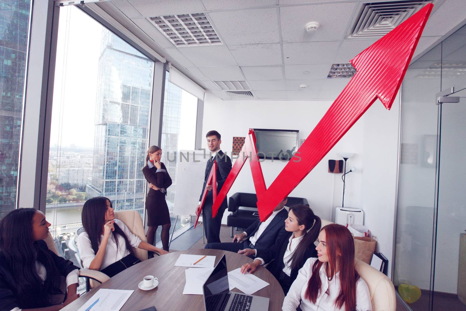 Business people discuss red arrow of income growth at meeting