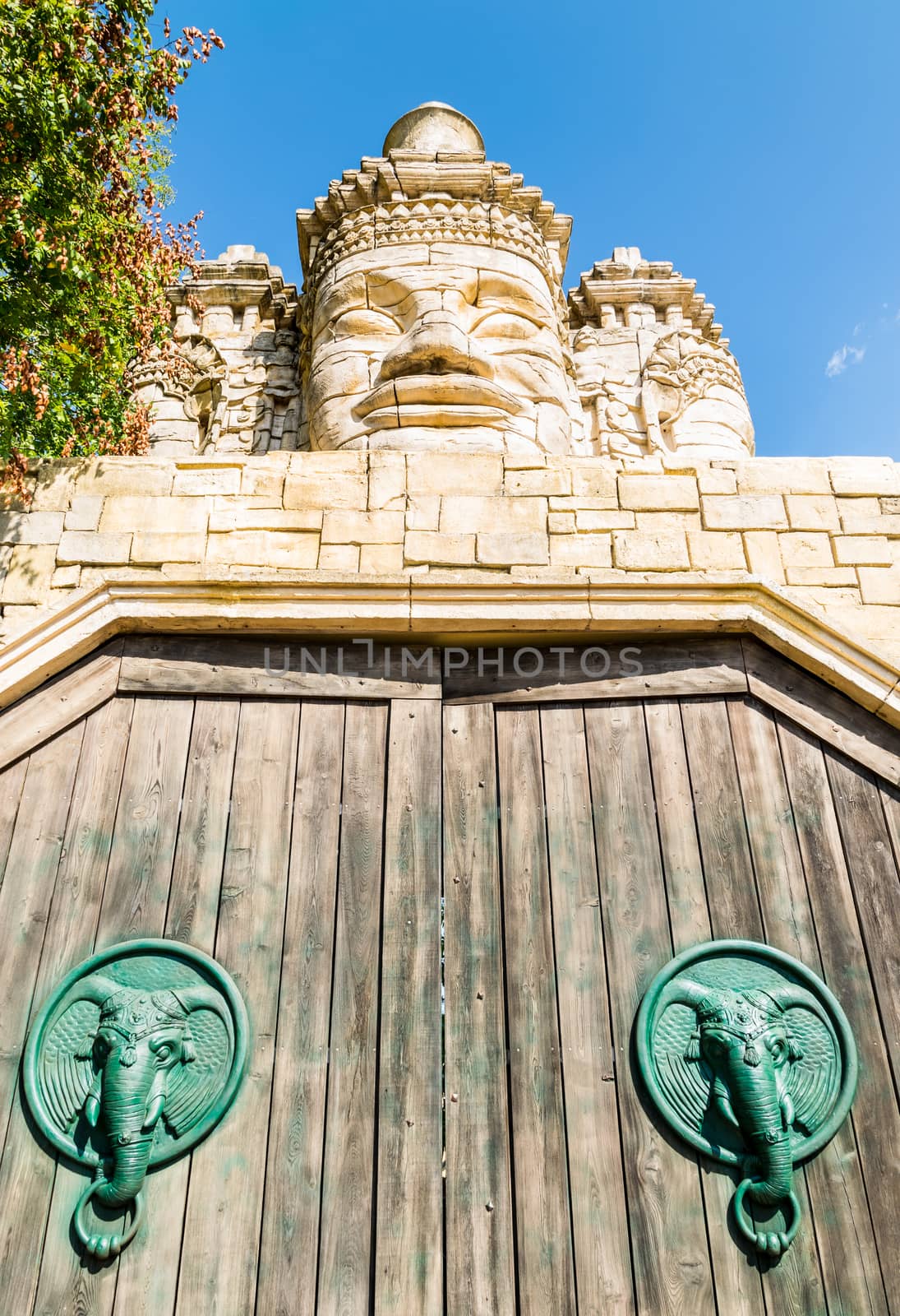 Stone faces of a temple and wooden portal. by Isaac74