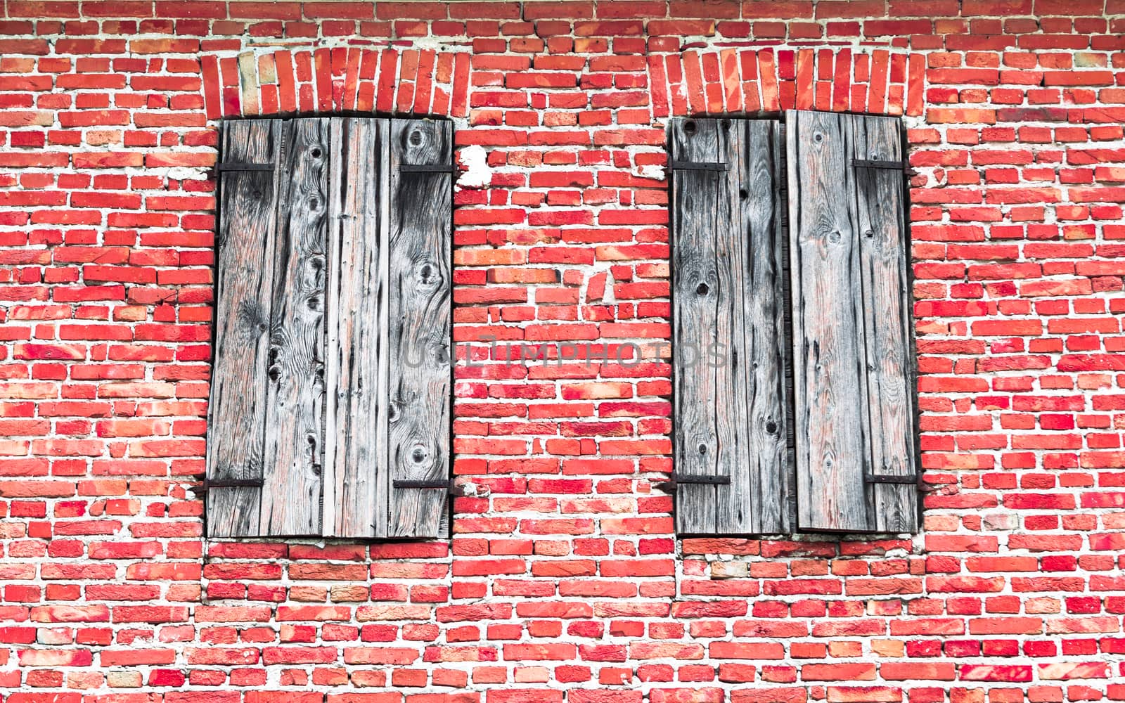 Windows with wooden frames on brick wall. by Isaac74