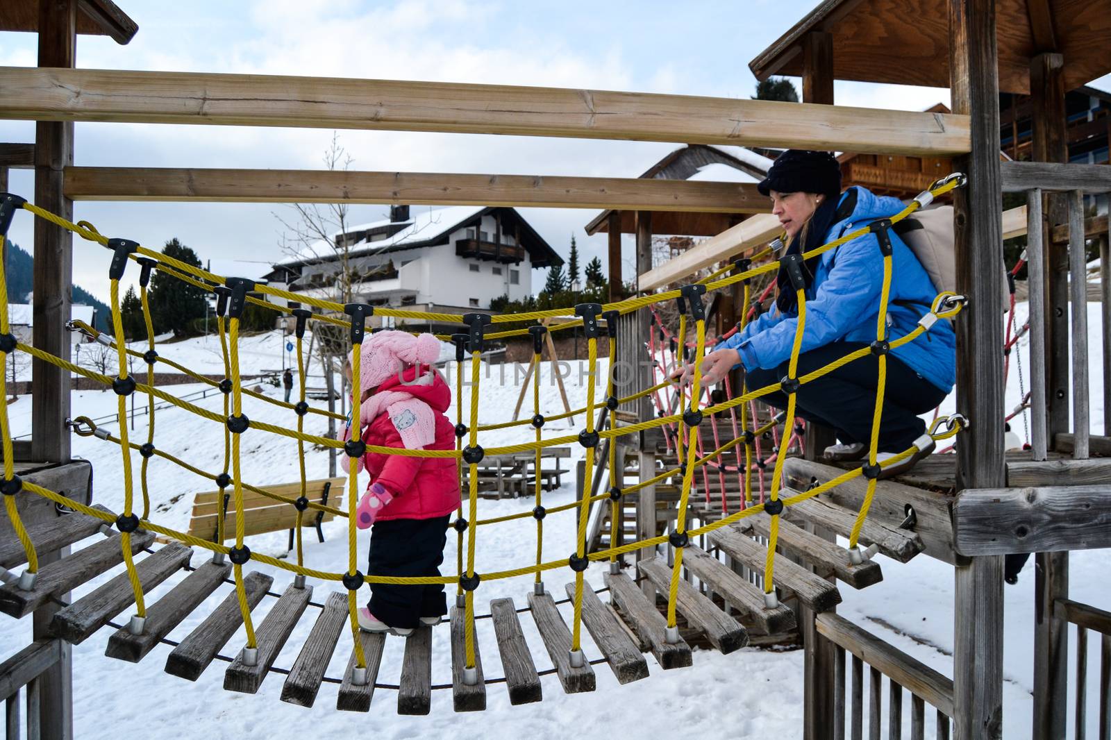 Mom and daughter in a snowy playground. by Isaac74